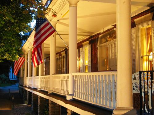 Exterior of the inn and its porch at sunset with American flags hanging from the columns.